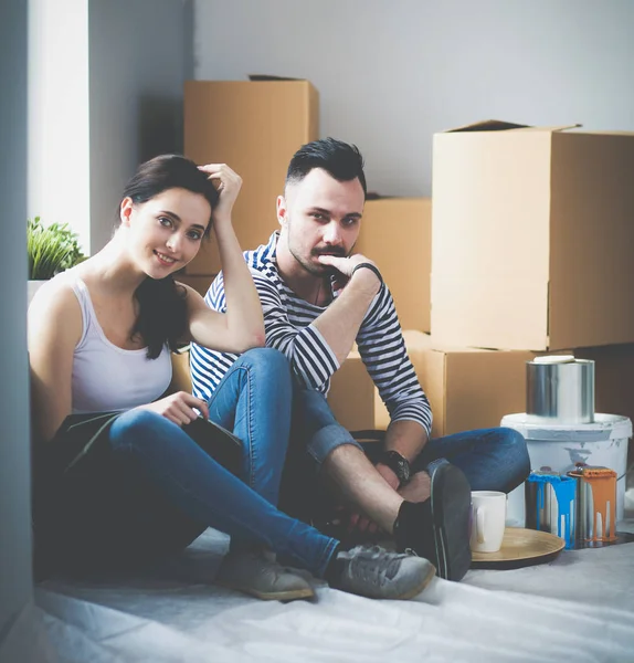 Couple moving in house sitting on the floor . Couple