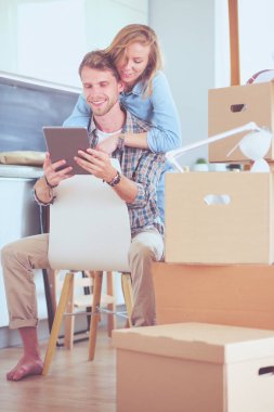 Genç bir çift yeni ev içinde hareket. Oturma ve açma sonra rahatlatıcı. Bir şey üstünde laptop arıyorum. Genç Çift