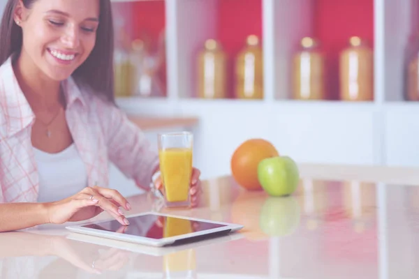 Uma jovem na cozinha, a usar o ipad. Jovem mulher — Fotografia de Stock