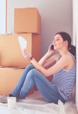 Kadın seçerek boya rengi renk örneği yeni ev ahşap yere oturmak için. Kadın evde