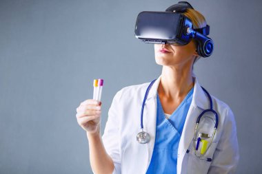 Sanal gerçeklik gözlüğü takan kadın doktor beyaz arka planda izole edilmiş..