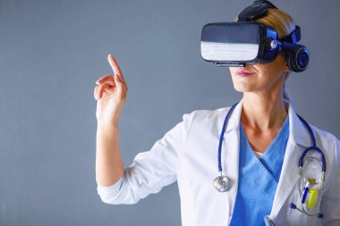 Sanal gerçeklik gözlüğü takan kadın doktor beyaz arka planda izole edilmiş..
