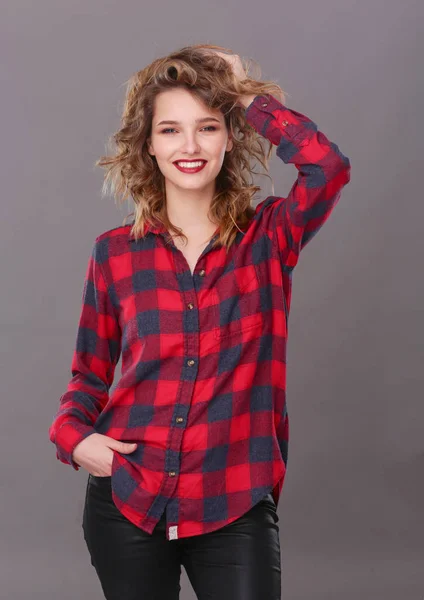 Young woman standing, isolated on gray background. — Stock Photo, Image