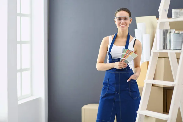 Jovem segurando uma amostra de cor com uma pintura de pintor  . — Fotografia de Stock