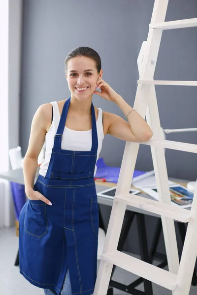 Arbeiterfrau mit Bohrmaschine steht in neuem Heim. — Stockfoto