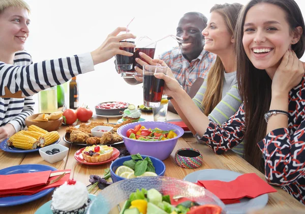 Vista superior do grupo de pessoas que jantam juntas enquanto estão sentadas à mesa de madeira. Comida na mesa. As pessoas comem fast food. — Fotografia de Stock