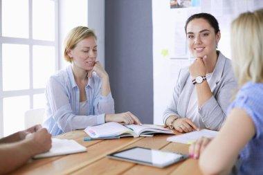 Masada kitaplarla çalışan gençler. Güzel kadınlar ve erkekler birlikte çalışıyor..
