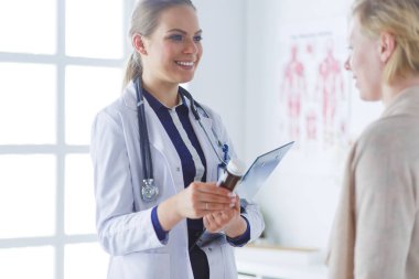 Doktor ve hasta masada otururken bir şey tartışıyorlar. İlaç ve sağlık hizmetleri kavramı