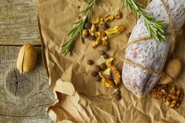 İtalyan salamı, deniz tuzu, biberiye, sarımsak ve fındık. Kırsal tarzda. Üst görünüm.