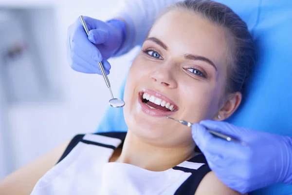Ung kvinnlig patient med öppen mun undersöker tandläkarundersökning på tandläkarmottagningen. — Stockfoto