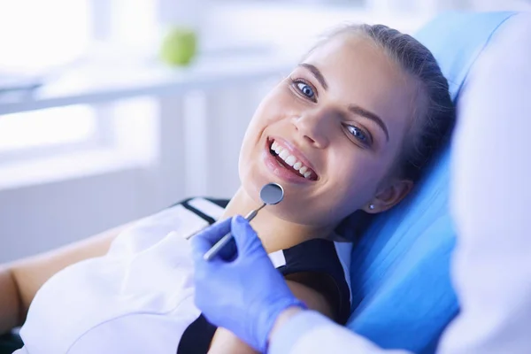 Joven paciente femenina con sonrisa bonita examinando la inspección dental en el consultorio del dentista. — Foto de Stock