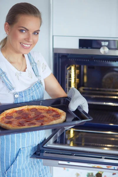 Feliz joven cocinando pizza en casa — Foto de Stock