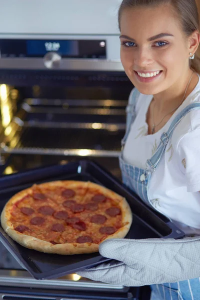 Happy young woman cooking pizza at home — Stock Photo, Image