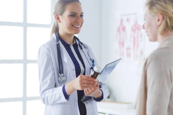 Doctor y paciente discutiendo algo mientras están sentados en la mesa. Concepto de medicina y salud — Foto de Stock