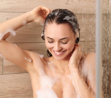 Genç beautyful kadın banyoda duş altında.