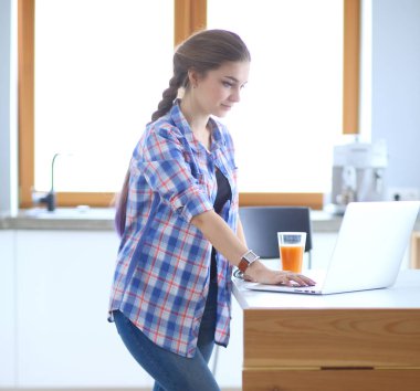 Güzel, genç, gülümseyen bayan doktor masada oturuyor ve yazıyor..