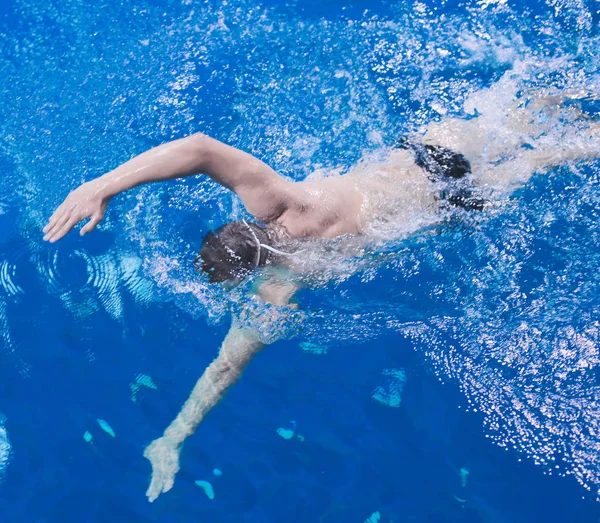 Male swimmer at the swimming pool. Underwater photo. Male swimmer