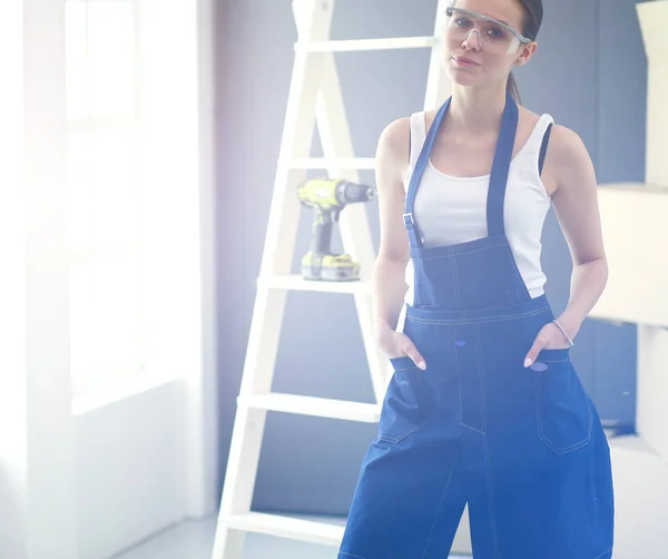 Worker woman with drill standing in new home — Stock Photo, Image