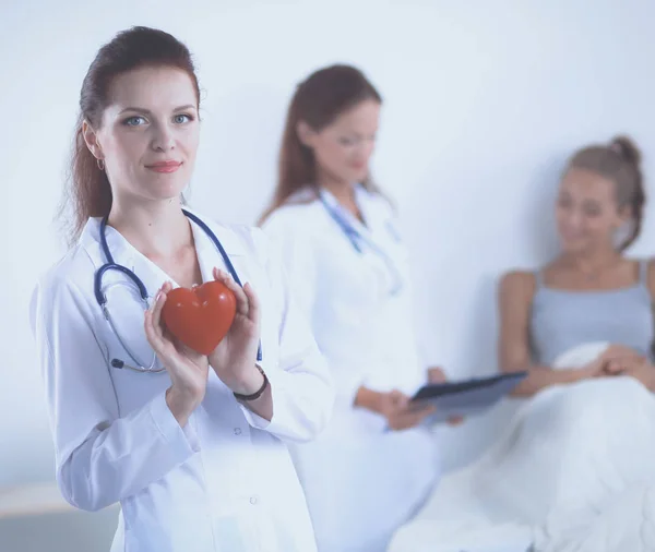 Woman doctor withred heart symbol standing at hospital. Woman doctor