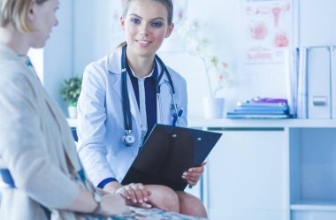 Doktor ve hasta masada otururken bir şey tartışıyorlar. İlaç ve sağlık hizmetleri kavramı