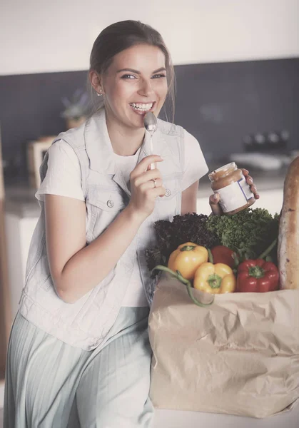 Young woman holding grocery shopping bag with vegetables .Standing in the kitchen — Stock Photo, Image