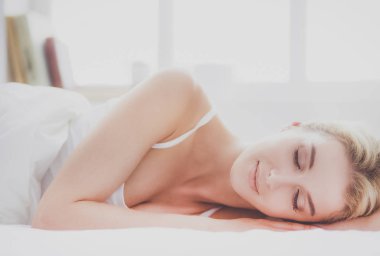 Güzel bir kadın yatağında uzanıyor..