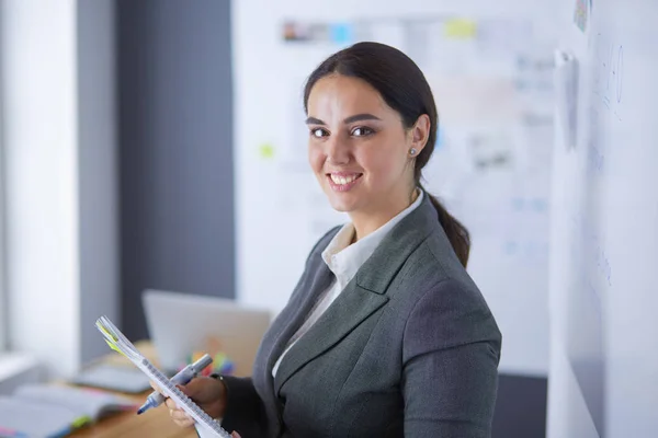 Business, formazione e concetto di ufficio - team di lavoro con flip board in ufficio discutendo di qualcosa. — Foto Stock