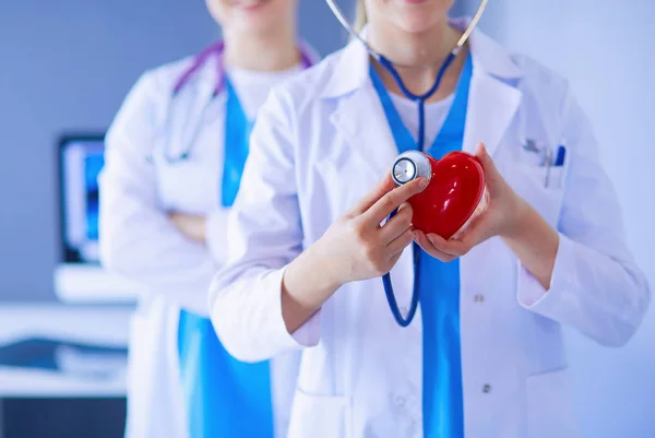 Gesneden opname van twee jonge artsen vrouw met stethoscoop houden hart. — Stockfoto