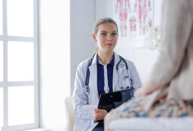 Doktor ve hasta masada otururken bir şey tartışıyorlar. İlaç ve sağlık hizmetleri kavramı