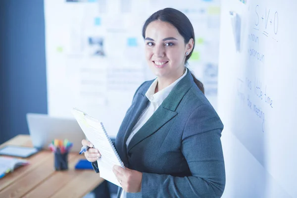 Business, formazione e concetto di ufficio - team di lavoro con flip board in ufficio discutendo di qualcosa. — Foto Stock