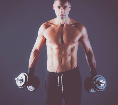 Yakışıklı kaslı adam dumbell ile çalışma dışarı. Kişisel fitness eğitmeni. Kişisel eğitim.