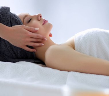 Masaj masasında uzanmış gözleri kapalı rahatlayan genç bir kadın. - Kadın. Spa salonu