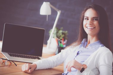 Masada oturan genç bir kadın..