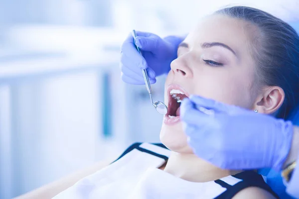 Mujer joven con la boca abierta examinando la inspección dental en el consultorio del dentista. — Foto de Stock