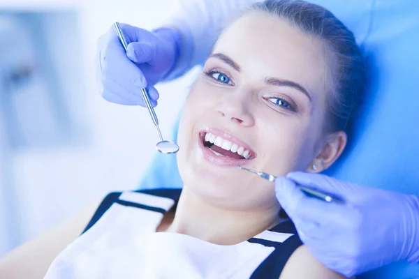 Mujer joven con la boca abierta examinando la inspección dental en el consultorio del dentista. — Foto de Stock