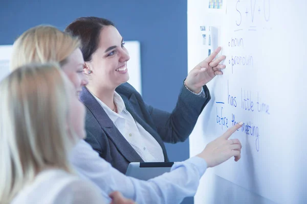 Business, education and office concept - business team with flip board in office discussing something. — Stock Photo, Image