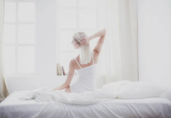 Woman stretching in bed after wake up, back view — Stock Photo, Image