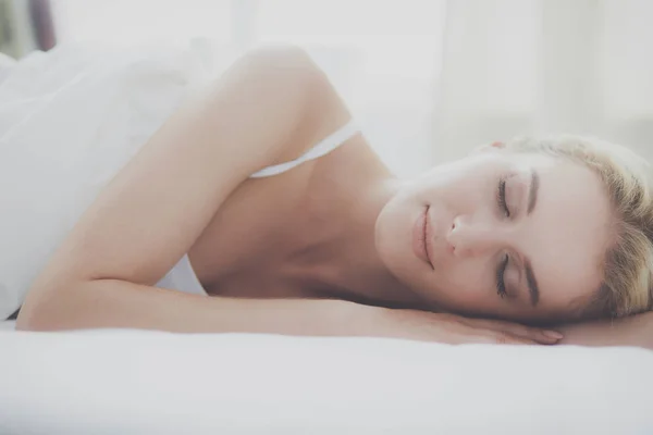 Vacker kvinna som ligger på sin säng hemma — Stockfoto
