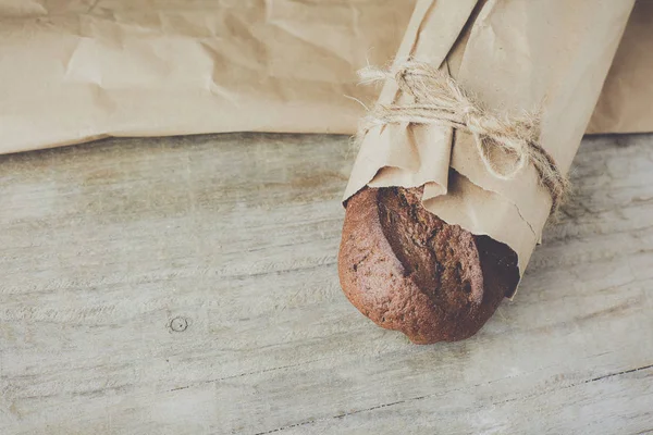 木製のテーブルの上に紙に詰めパンのスライスローフ. — ストック写真
