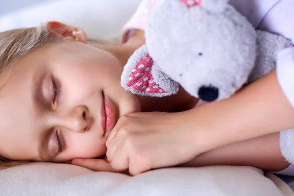 Bambino bambina dorme nel letto con un orsacchiotto giocattolo — Foto Stock