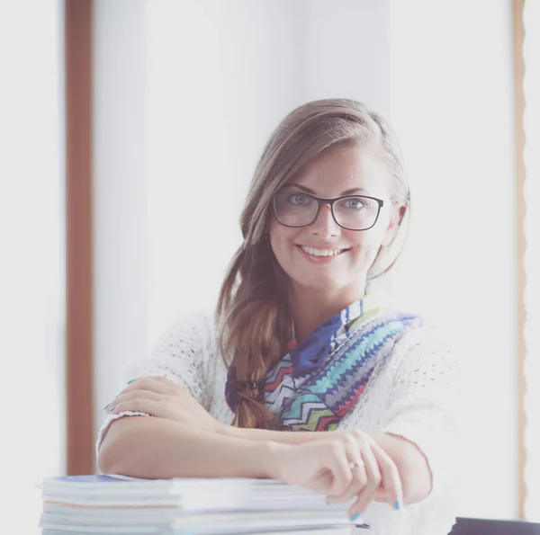 Jeune femme assise à un bureau parmi les livres. Étudiant — Photo