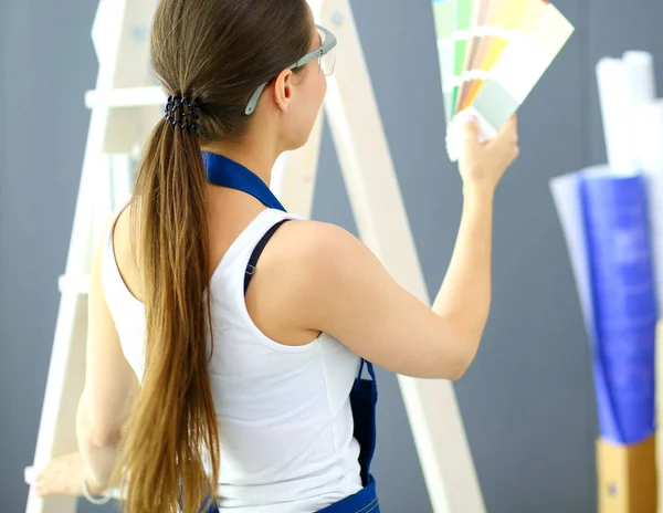 Jovem segurando uma amostra de cor com uma pintura de pintor — Fotografia de Stock