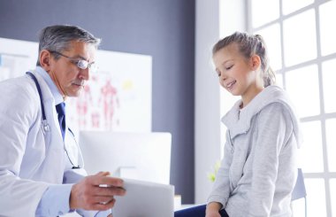 Küçük tatlı bir kız ve hastanedeki doktorunun portresi.