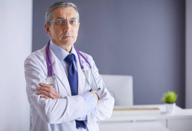 Parlak ofisinde gülümseyen bir doktorun portresi.