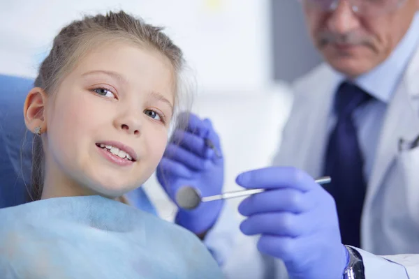 Lille pige sidder på tandlægekontoret - Stock-foto