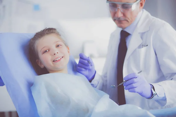 Niña sentada en el consultorio de dentistas — Foto de Stock