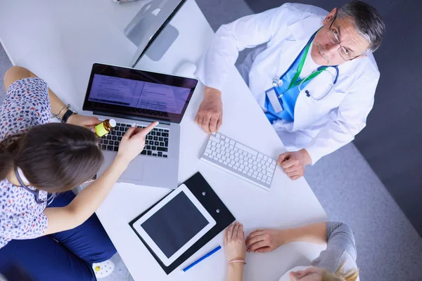 Médico e paciente discutindo algo enquanto se senta na mesa. Conceito de medicina e cuidados de saúde — Fotografia de Stock