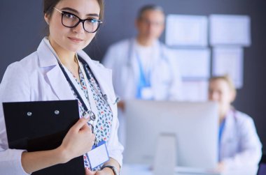 Kadın doktor hastanede steteskopla dikiliyor.