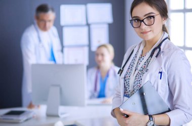 Kadın doktor hastanede steteskopla dikiliyor.