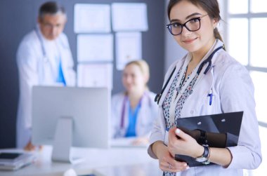 Kadın doktor hastanede steteskopla dikiliyor.